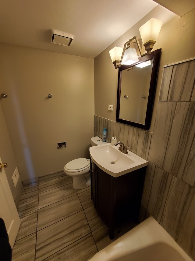 bathroom featuring toilet, tile flooring, and vanity