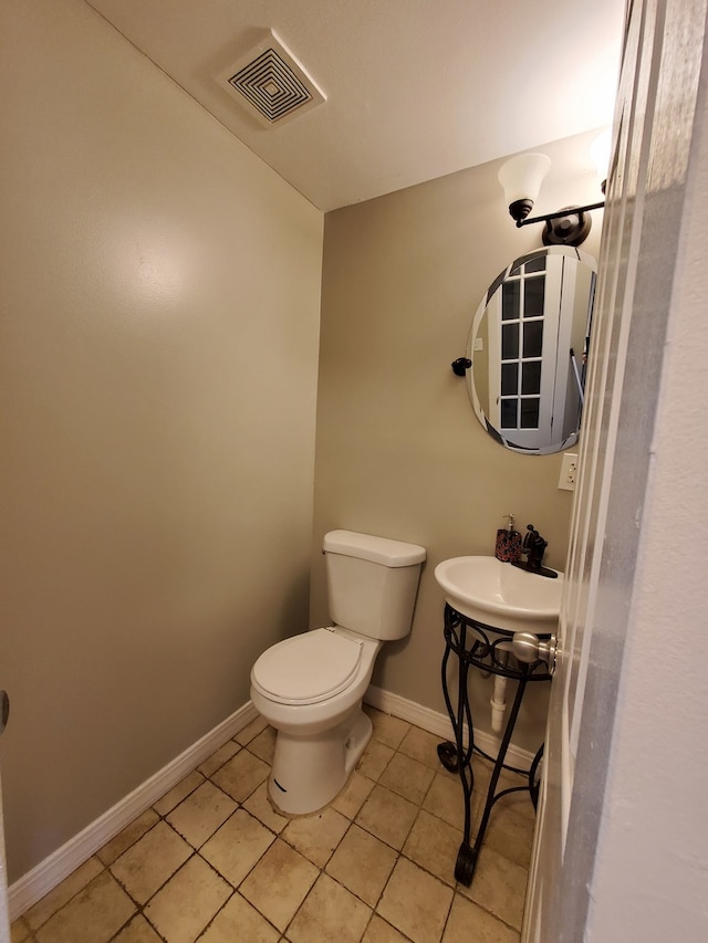 bathroom with sink, tile floors, and toilet