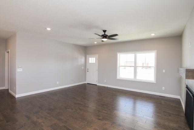 unfurnished living room featuring ceiling fan and dark hardwood / wood-style floors