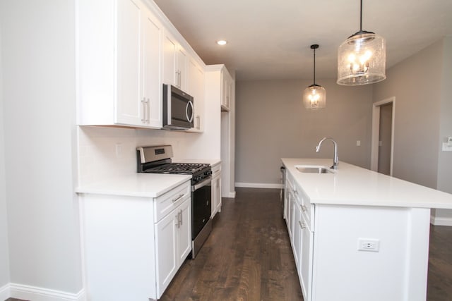 kitchen with dark hardwood / wood-style flooring, decorative light fixtures, a center island with sink, stainless steel appliances, and sink