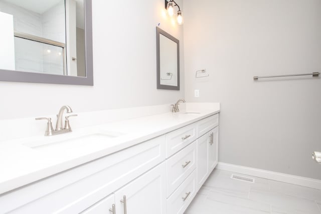 bathroom with tile floors, dual sinks, and vanity with extensive cabinet space