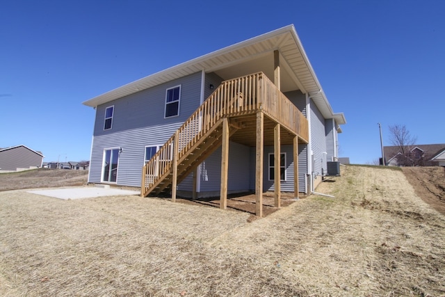 rear view of property featuring a wooden deck and central AC unit