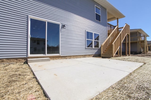 back of house with a deck and a patio