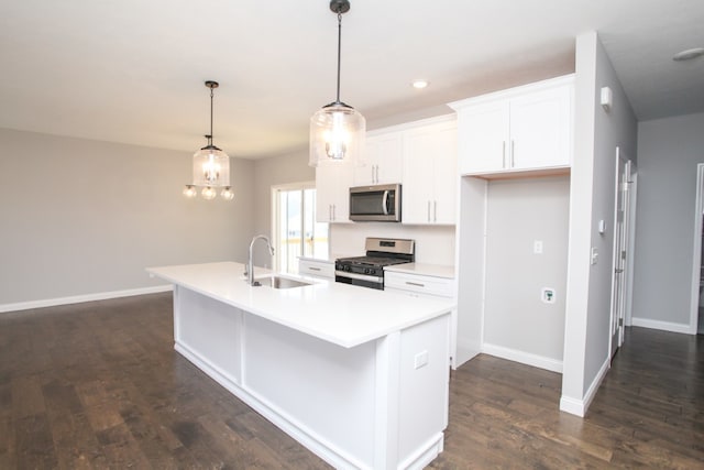 kitchen featuring appliances with stainless steel finishes, dark hardwood / wood-style flooring, sink, white cabinetry, and a center island with sink