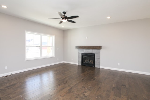 unfurnished living room with dark hardwood / wood-style flooring, ceiling fan, and a fireplace