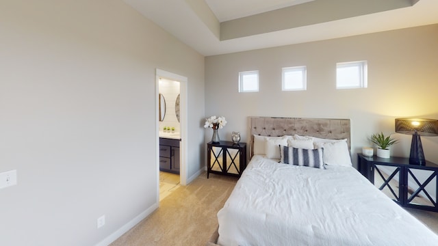 bedroom featuring light colored carpet and ensuite bath