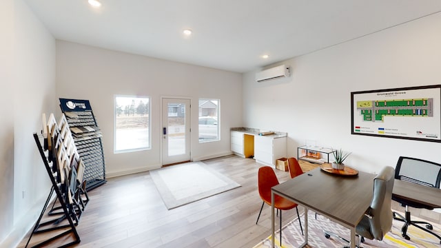 interior space featuring a wall mounted AC and light hardwood / wood-style flooring