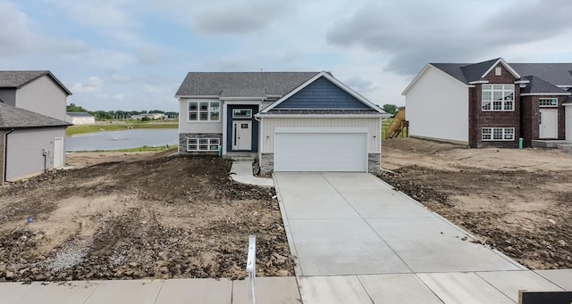 view of front of home with a garage and a water view