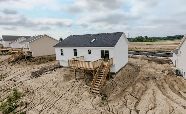 rear view of property featuring roof with shingles, stairway, a wooden deck, and central air condition unit