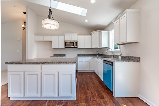 kitchen with dishwashing machine, stainless steel microwave, a sink, white cabinetry, and lofted ceiling with skylight