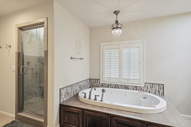 bathroom featuring a notable chandelier and independent shower and bath