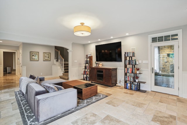 living room featuring light tile flooring and decorative columns