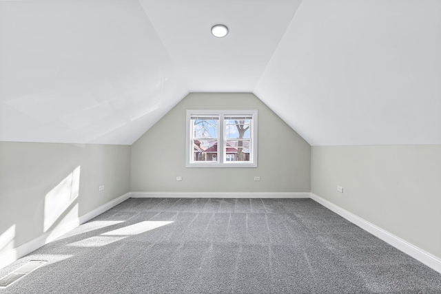 bonus room with light carpet and vaulted ceiling