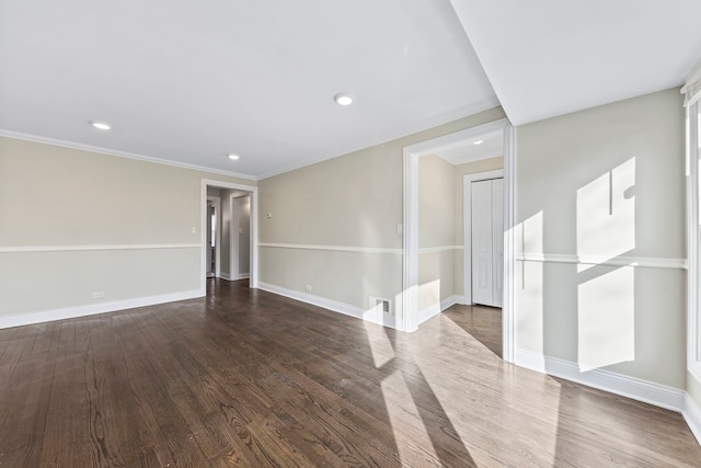 empty room featuring dark wood-type flooring and ornamental molding