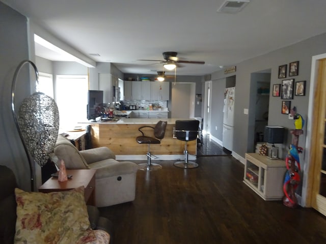 living room with dark hardwood / wood-style floors and ceiling fan