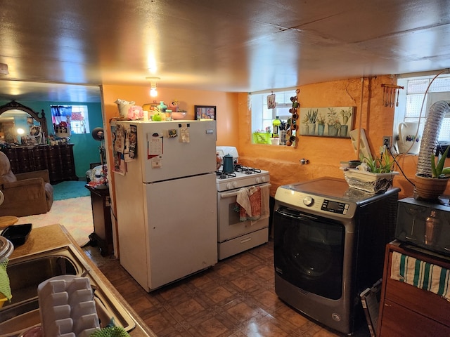 kitchen with white appliances and washer / dryer