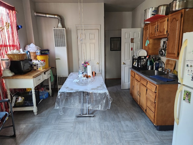 kitchen featuring hanging light fixtures, white fridge, and sink