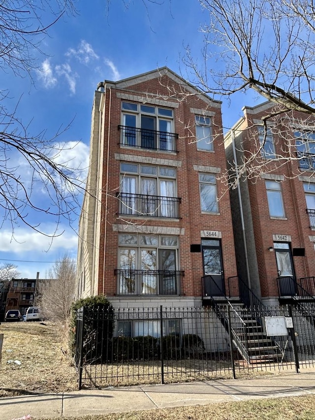 view of front of home featuring brick siding and a fenced front yard