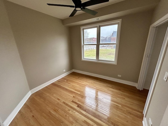unfurnished room featuring visible vents, light wood-style flooring, ceiling fan, and baseboards
