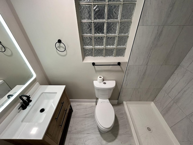 bathroom featuring vanity, baseboards, toilet, marble finish floor, and a tile shower