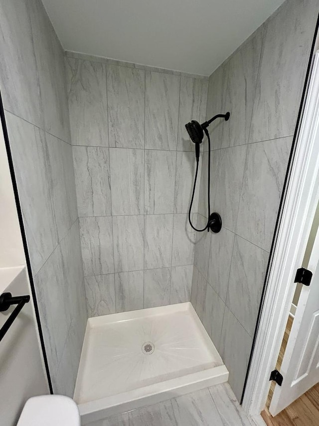 full bath featuring toilet and a stall shower