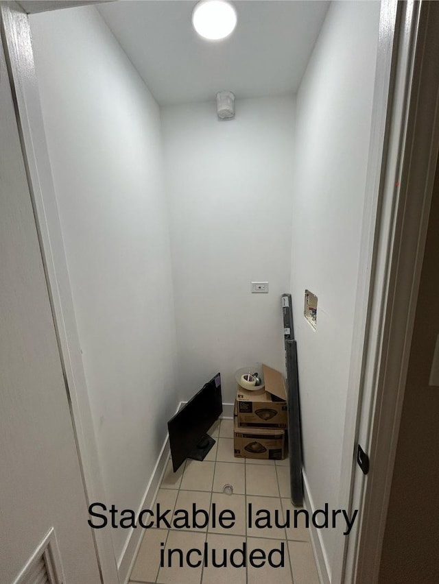 interior space with laundry area, light tile patterned floors, and baseboards