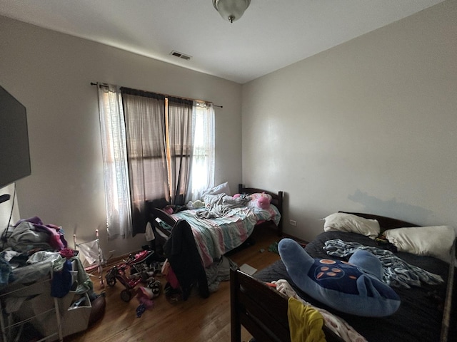 bedroom with visible vents and wood finished floors