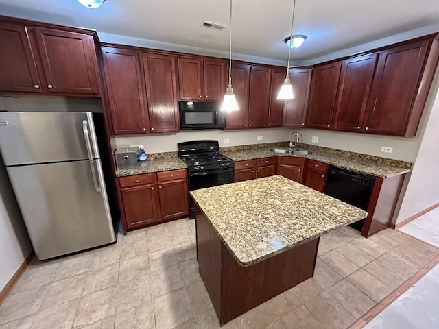 kitchen with pendant lighting, visible vents, black appliances, light stone counters, and a sink