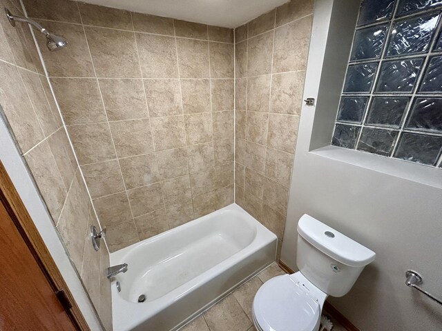 full bath featuring tile patterned floors, washtub / shower combination, and toilet