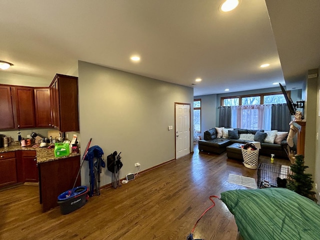 living room with dark wood-type flooring, baseboards, and recessed lighting