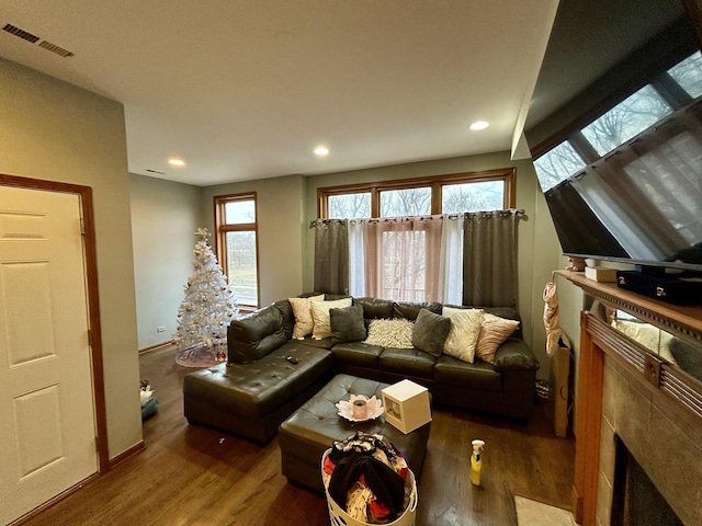 living room with wood finished floors, visible vents, and a healthy amount of sunlight