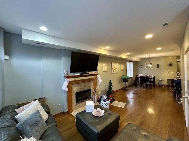 living room with wood finished floors, visible vents, and recessed lighting