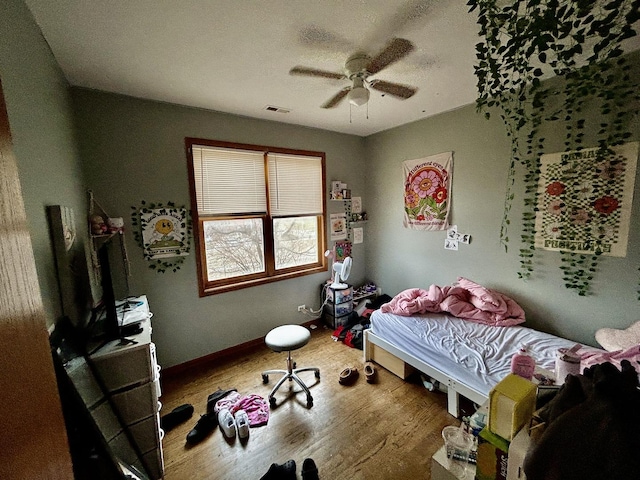 bedroom with visible vents, ceiling fan, and wood finished floors