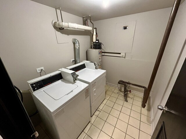 washroom featuring light tile patterned floors, washing machine and clothes dryer, and gas water heater