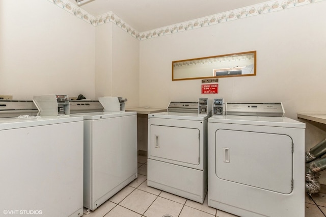 laundry room featuring washing machine and clothes dryer and light tile flooring