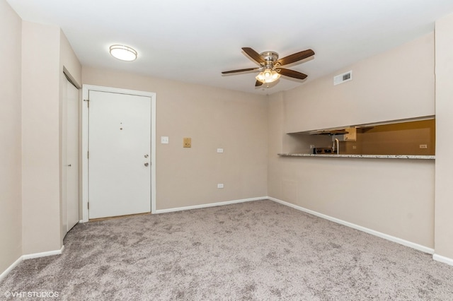 unfurnished room featuring ceiling fan and light carpet