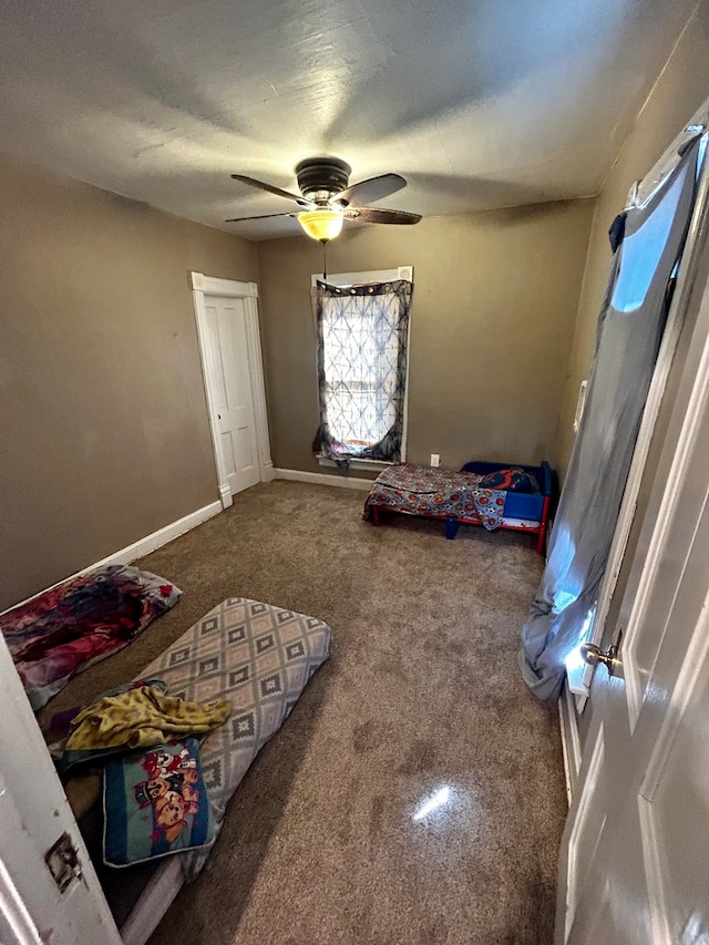 game room featuring ceiling fan and dark colored carpet