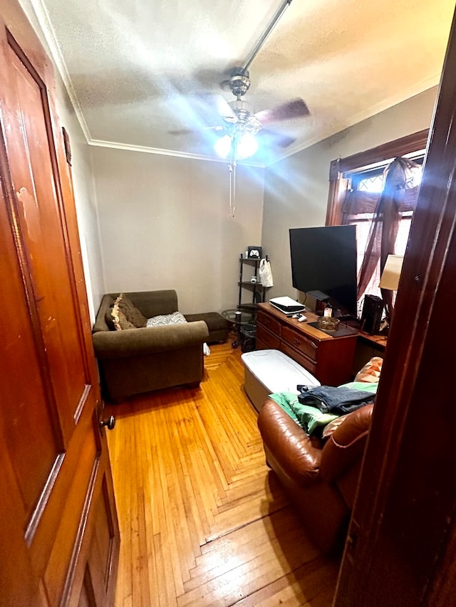 office area with light parquet flooring, a textured ceiling, ceiling fan, and ornamental molding