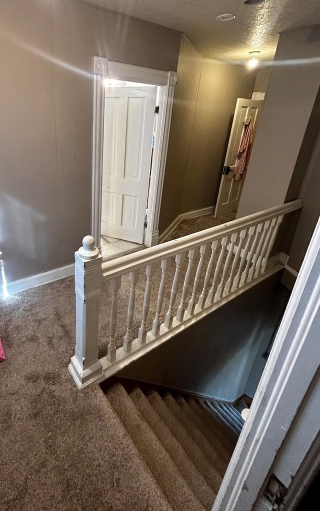 staircase with dark carpet