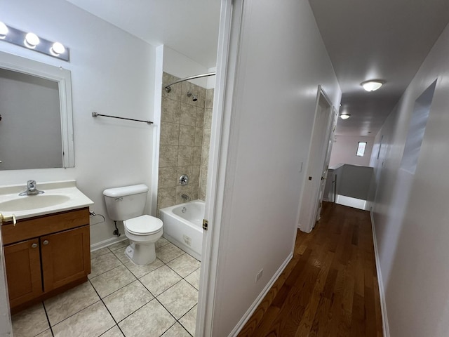 full bathroom featuring tiled shower / bath combo, vanity, tile patterned floors, and toilet