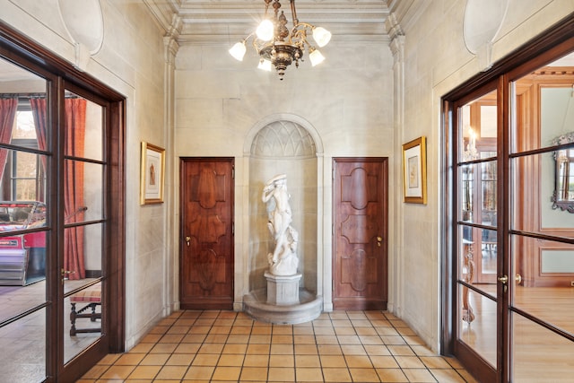 entrance foyer with ornamental molding, light hardwood / wood-style flooring, tile walls, and a chandelier