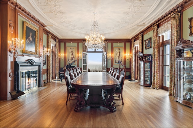 dining space with light hardwood / wood-style flooring, a wealth of natural light, a chandelier, and ornamental molding