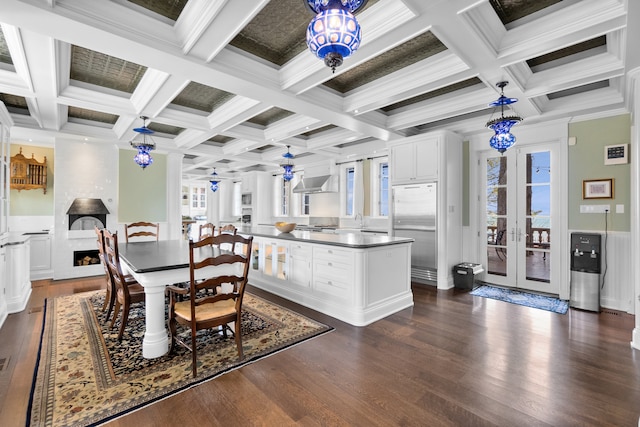 kitchen featuring stainless steel built in fridge, decorative light fixtures, white cabinetry, and coffered ceiling