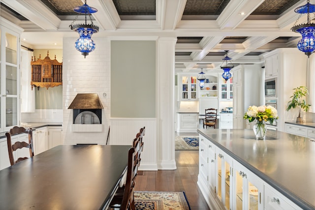 dining room featuring coffered ceiling, dark hardwood / wood-style floors, beamed ceiling, and crown molding