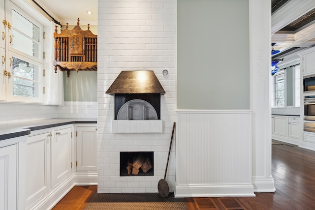 interior space featuring a fireplace, dark wood-type flooring, and crown molding