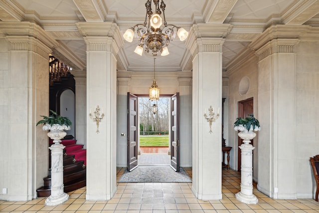 entrance foyer featuring ornamental molding, decorative columns, and light tile floors