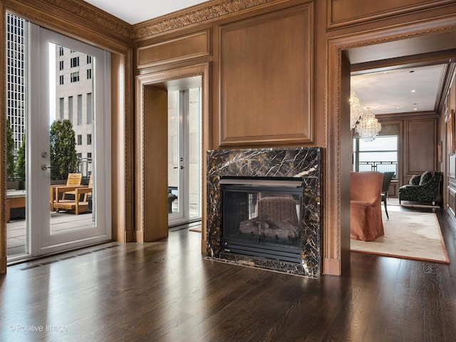 living room featuring a premium fireplace, ornamental molding, and dark hardwood / wood-style flooring