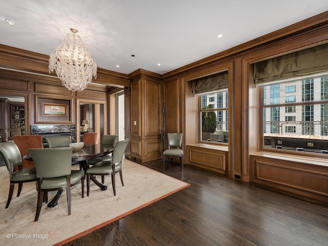 dining space with crown molding, a notable chandelier, dark hardwood / wood-style floors, and wooden walls