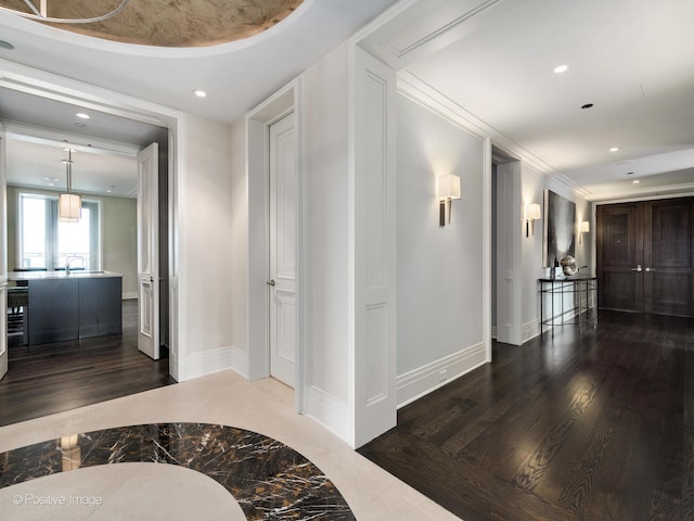 corridor featuring ornamental molding and dark hardwood / wood-style floors