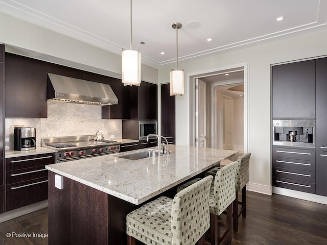 kitchen with a center island with sink, sink, wall chimney exhaust hood, decorative backsplash, and dark hardwood / wood-style floors